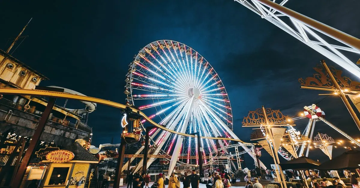 Boardwalk amusement rides lit up at night